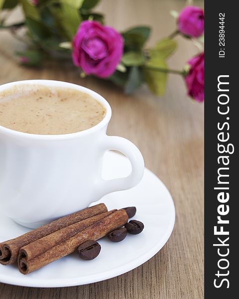 Cup of cappuccino with cinnamon and  coffee beans