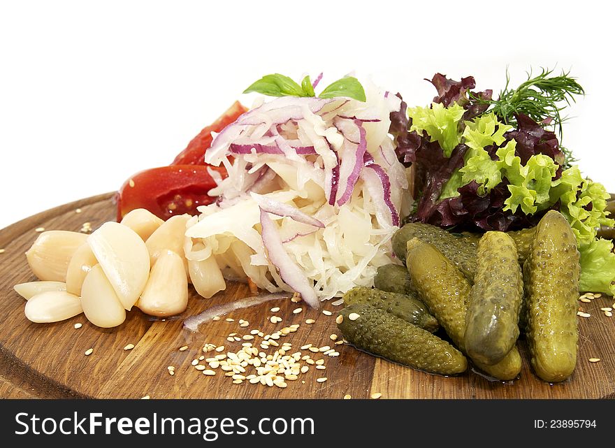 Wooden plate with pickles on a white background. Wooden plate with pickles on a white background