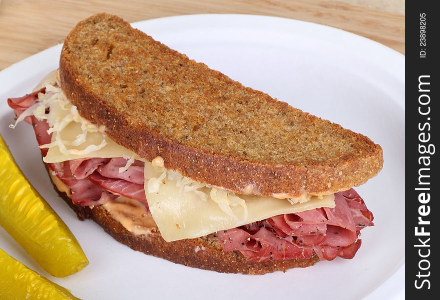 Grilled reuben sandwich with pastrami and swiss cheese on a plate