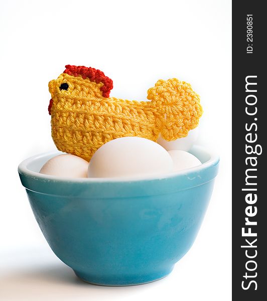 Bowl of eggs with a crocheted chicken cozy.