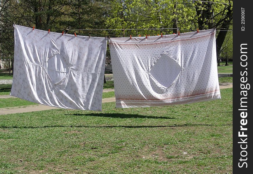 Washed drying bedclothes hanged out in yard