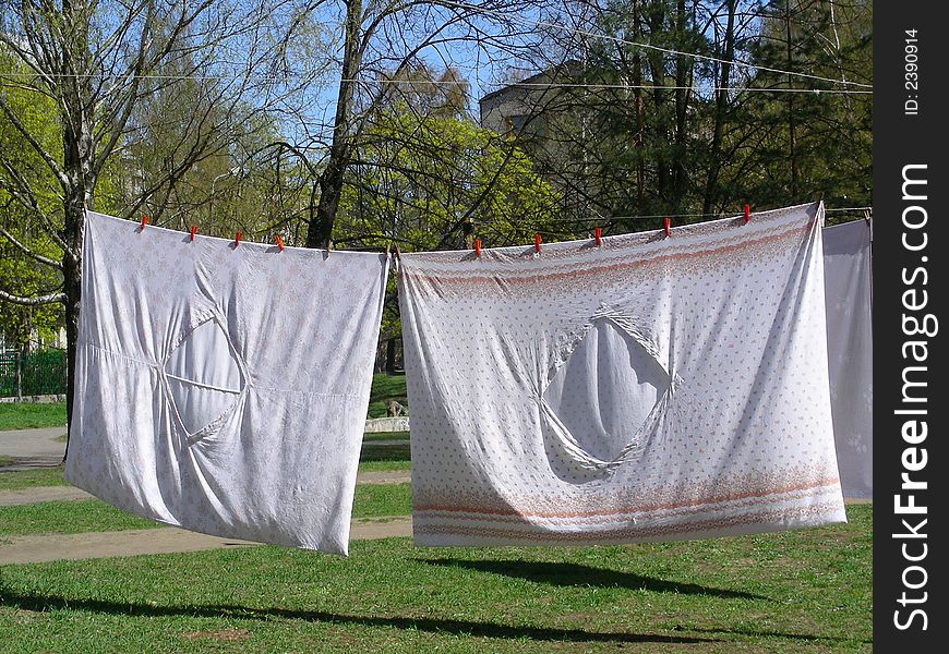 Washed drying bedclothes hanged out in yard. Washed drying bedclothes hanged out in yard