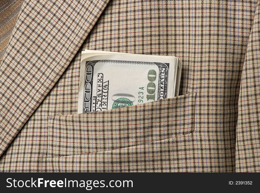 Money in a pocket of a checkered jacket