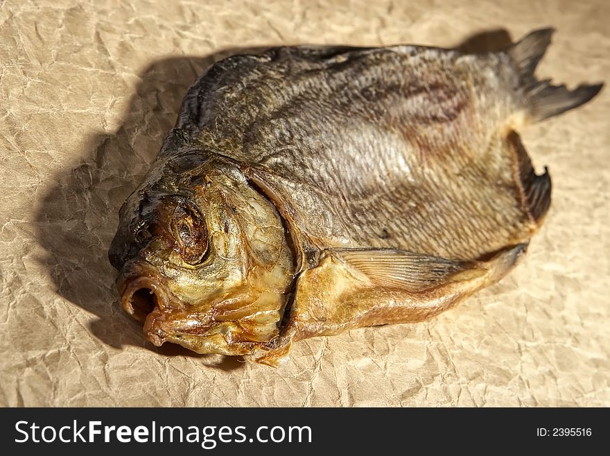 Dry fish snack-smoked herring on a textured paper