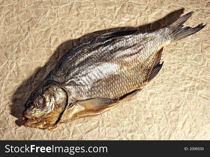 Dry fish snack-smoked herring on a textured paper