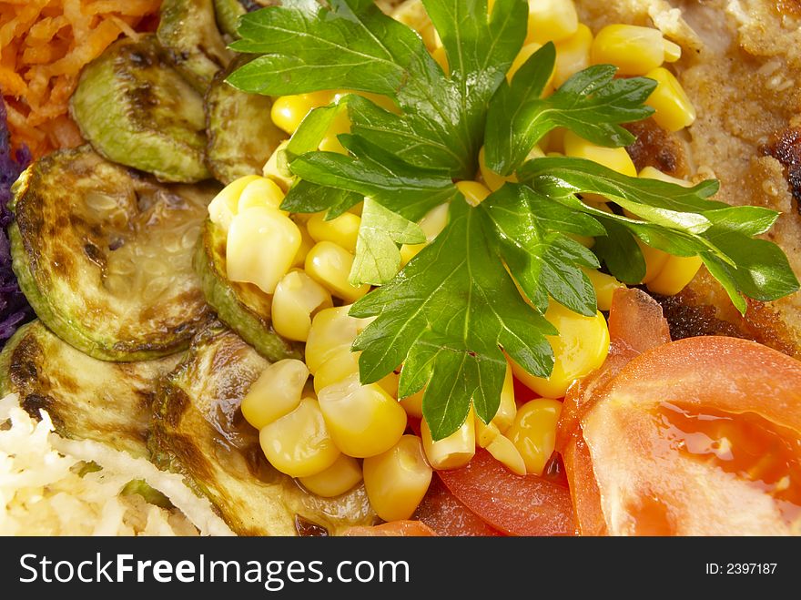 Fresh salad with tomatoes and corn fried zucchini