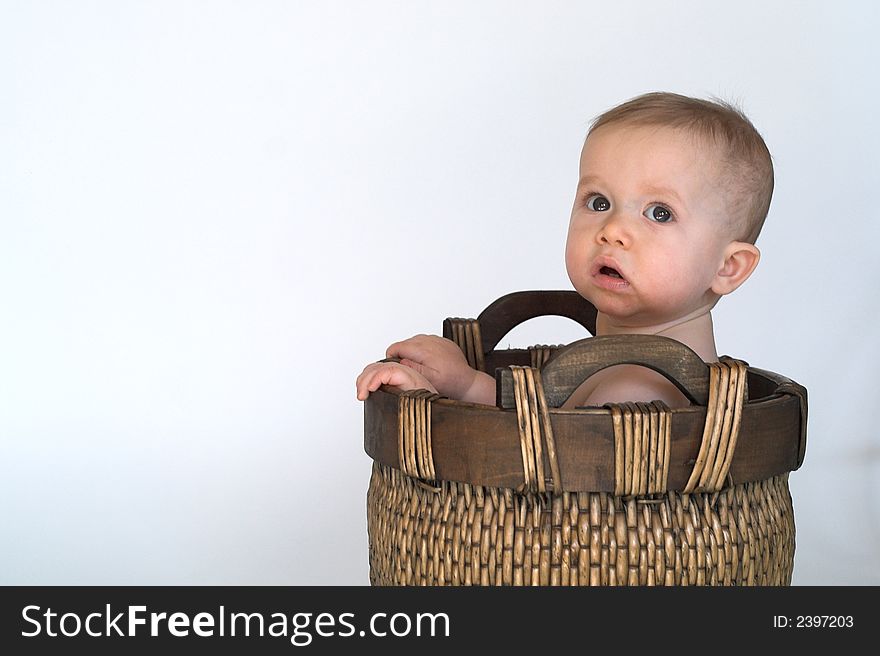 Image of cute baby sitting in a woven basket. Image of cute baby sitting in a woven basket