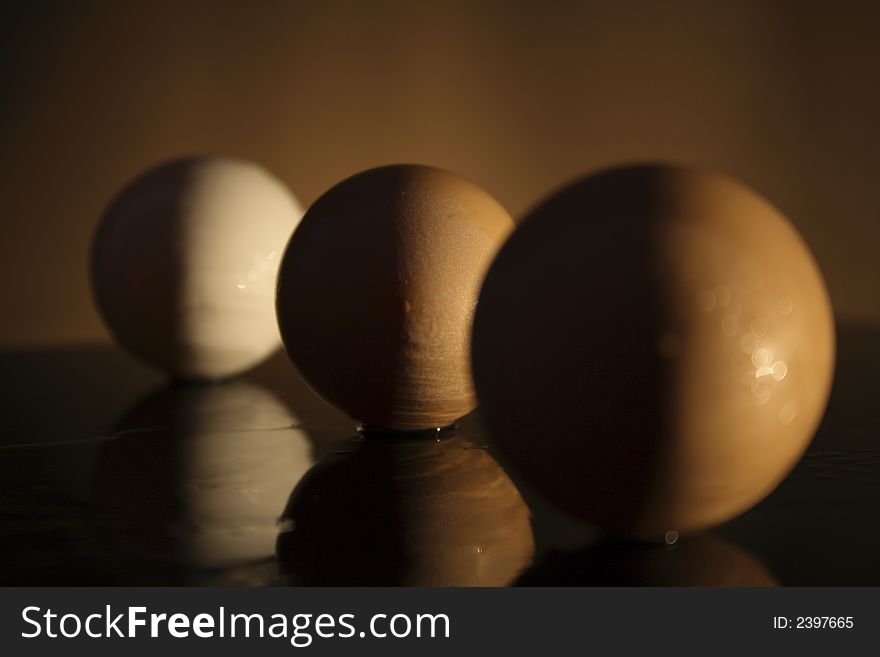 Three eggs with shadow on a dark background