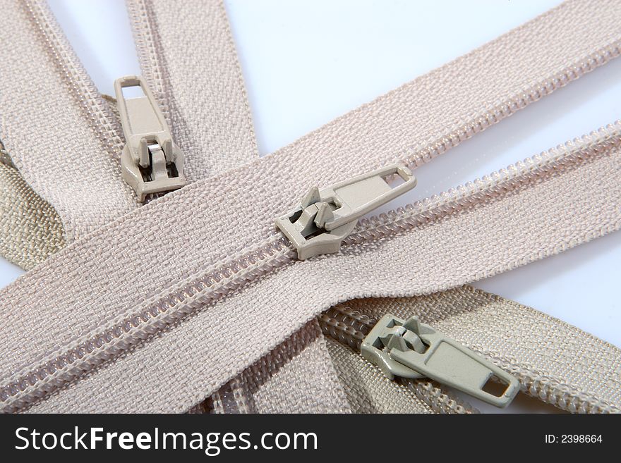 Three beige opened zippers for clothes