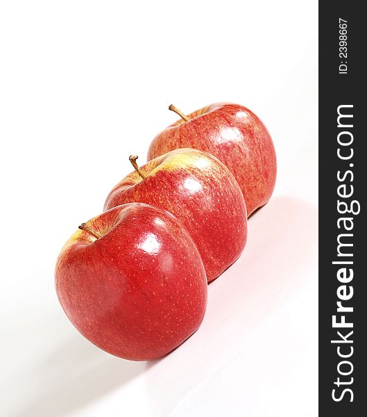 Close up of three red apples on a white background