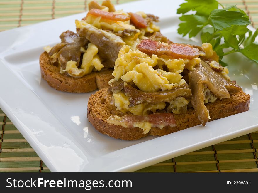 Scrambled eggs with mushrooms and bacon on toast. Scrambled eggs with mushrooms and bacon on toast.