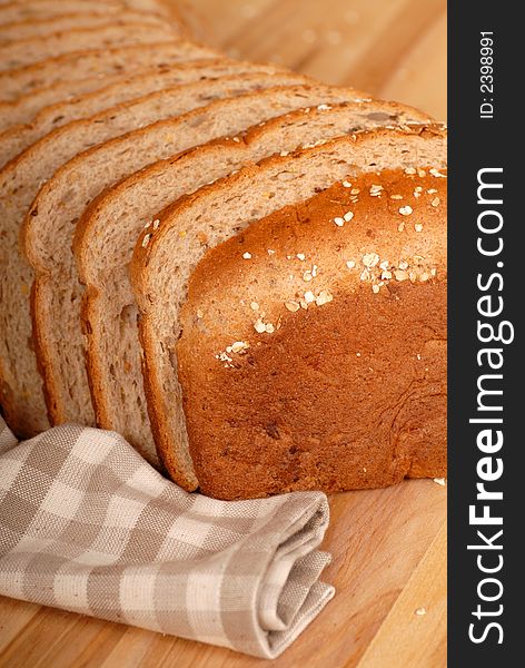 A close up of a loaf of multi grain bread on a cutting board