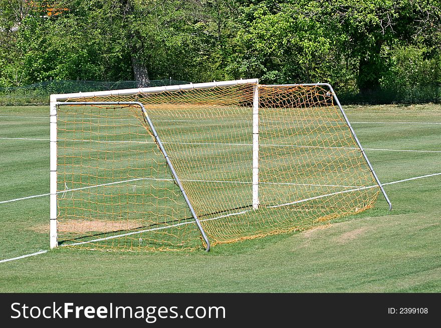 The net goal on a green soccer field. The net goal on a green soccer field