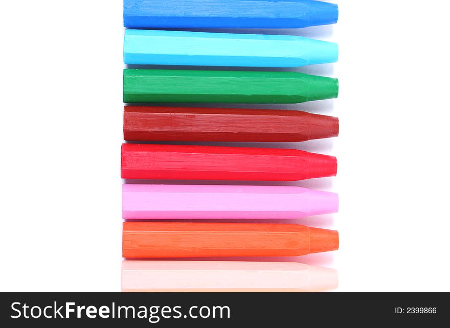 Row of brightly colored crayons isolated on white