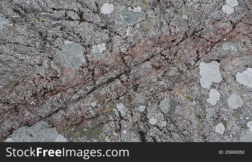 The surface of the granite stone with patches of lichens. Can be used as background