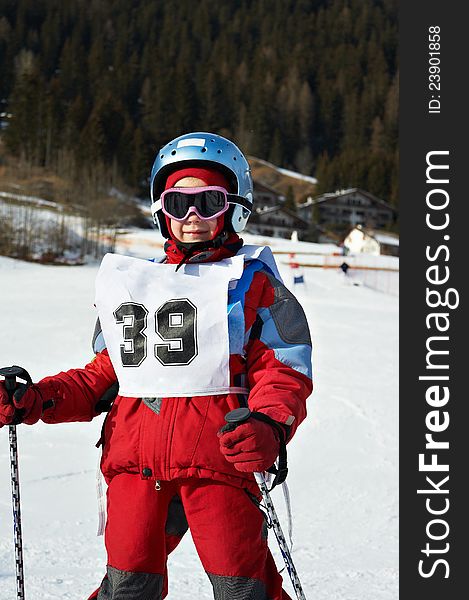 Child on helmet and with sports number  in the ski resort. Child on helmet and with sports number  in the ski resort