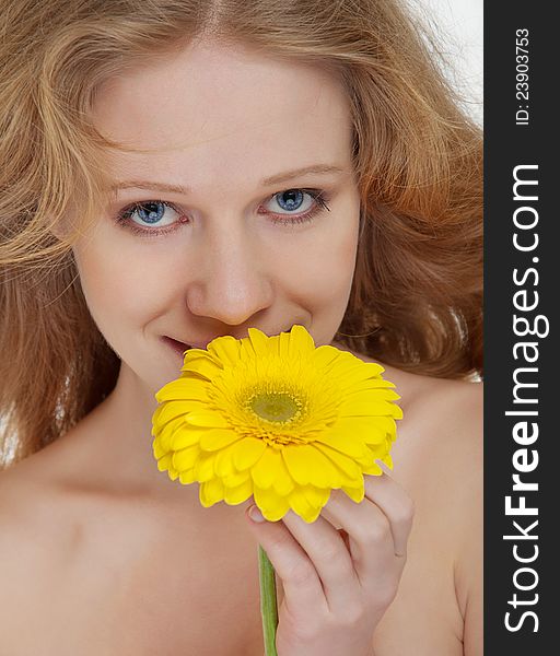 Beautiful blonde girl with yellow gerbera flower