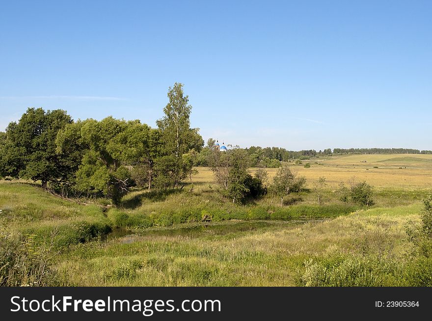 Rural landscape with a small river and sloping field