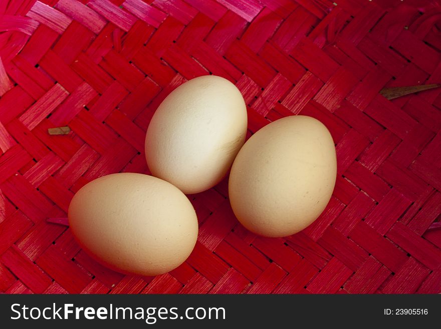 Three big ecological chicken eggs in red wicker basket. Three big ecological chicken eggs in red wicker basket.