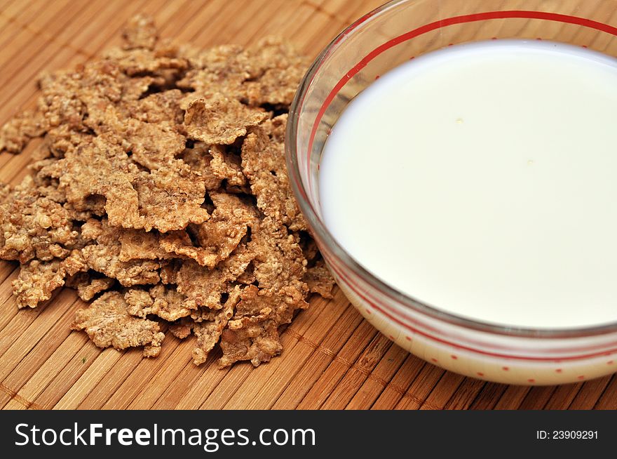 Cereal flakes and cup of milk over wooden background. Cereal flakes and cup of milk over wooden background