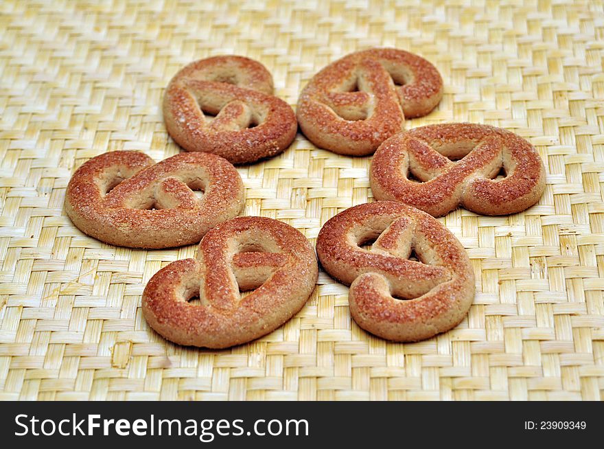 Braided biscuits with sugar over wicker surface