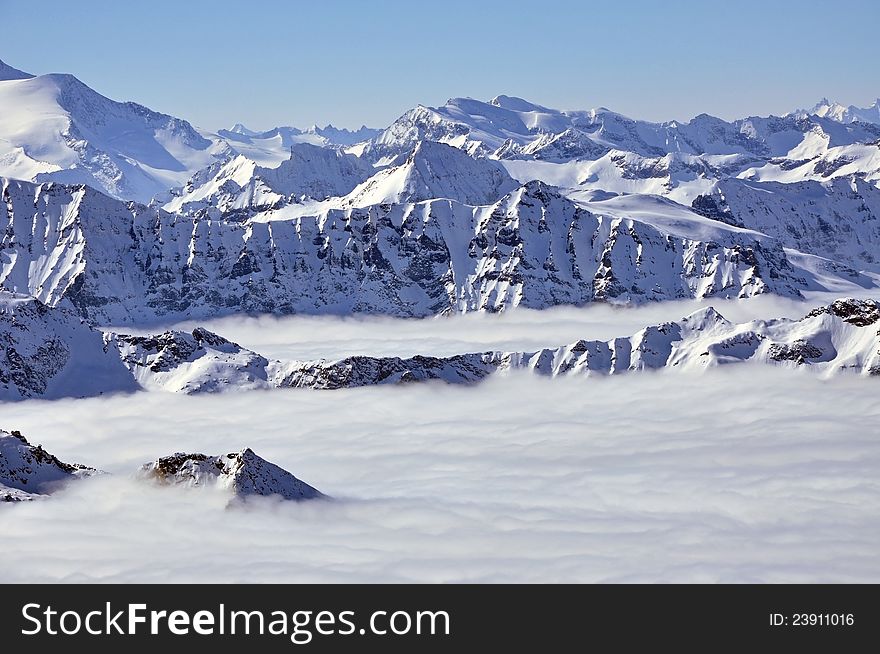 Peaks above clouds, winter in the Austrian Alps. View from Kitzsteinhorn, Kaprun.