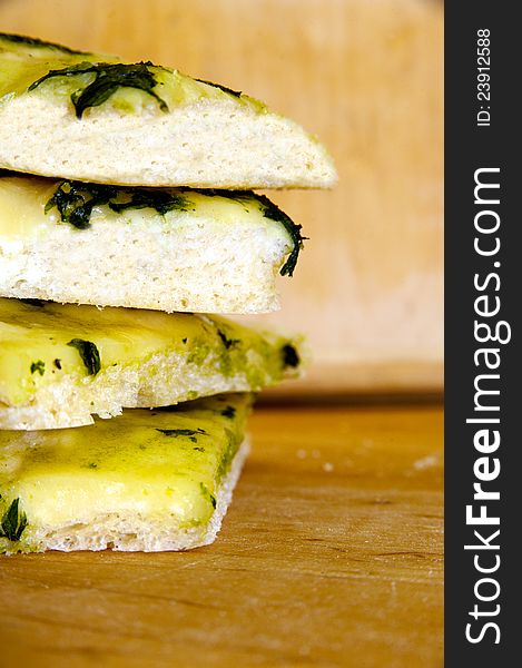 Focaccia - traditional Italian food with mozarella and basil paste. Pile of italian bread pices. Focaccia - traditional Italian food with mozarella and basil paste. Pile of italian bread pices.