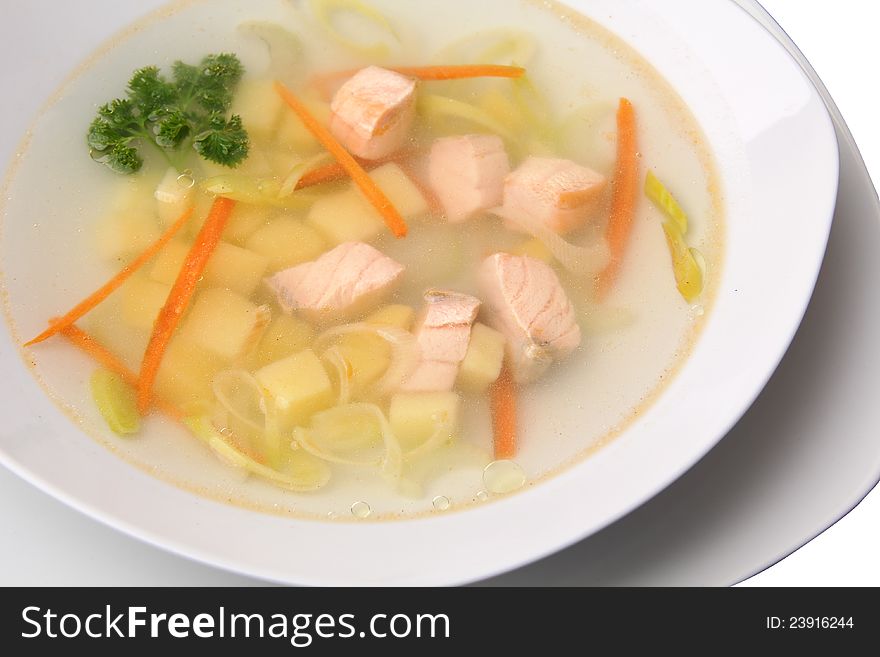 Close up soup with salmon in white plate over white background. Close up soup with salmon in white plate over white background