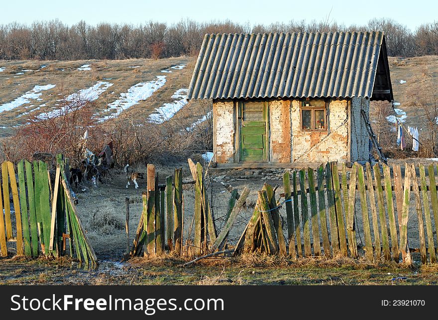 Isolated poor house with damaged fence