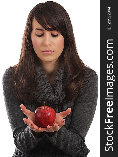 Young and attractive woman is staring at a red apple in her hands. Isolated with clipping path.