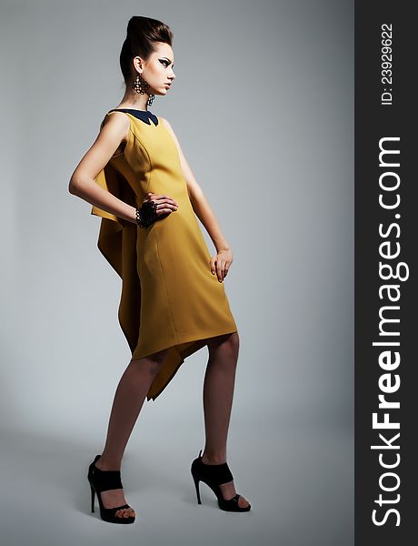 Fashion photo of beautiful stylish woman in yellow trendy dress. Studio shot. Fashion photo of beautiful stylish woman in yellow trendy dress. Studio shot