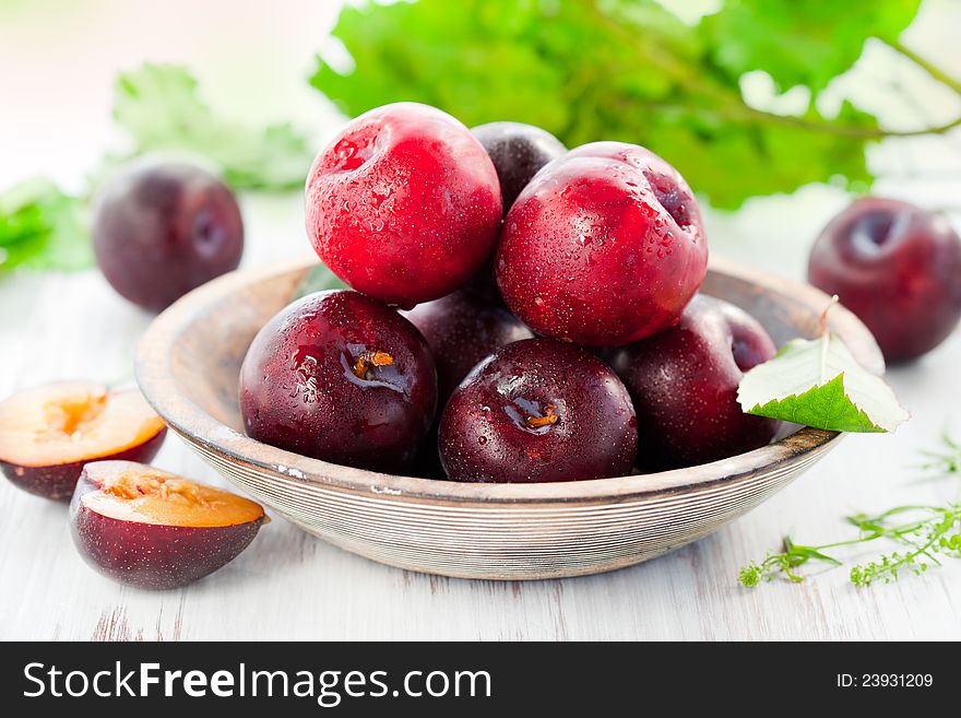 Fresh plums in bowl on the table