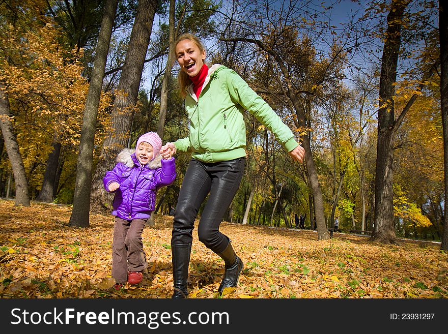 The women  with her daughter in the autumn park. The women  with her daughter in the autumn park