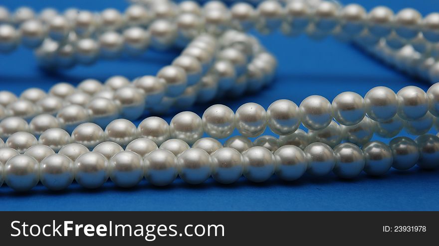 Pearls necklace on blue