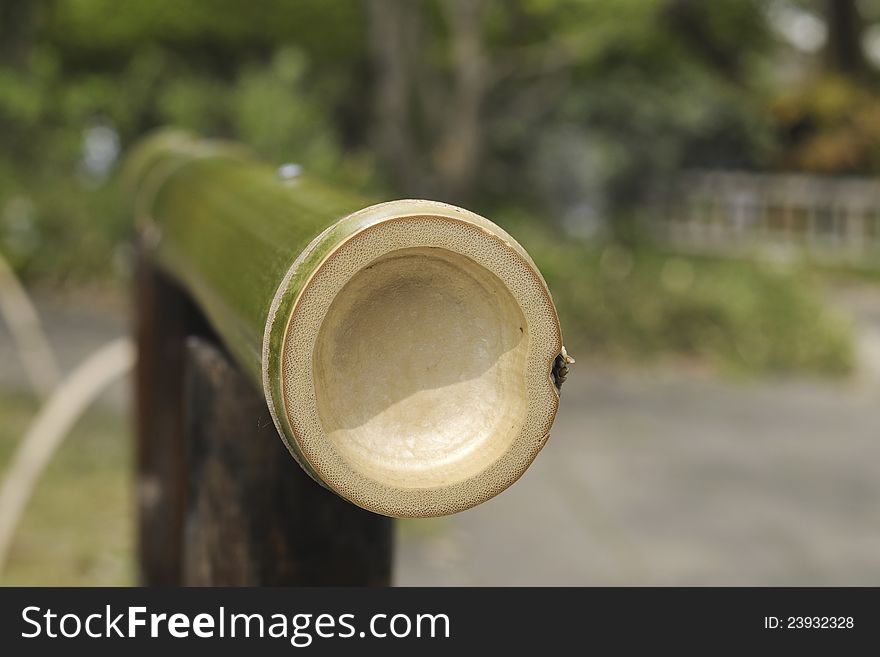 Fragment of bamboo fence in Japanese garden; focus on pole's end. Fragment of bamboo fence in Japanese garden; focus on pole's end