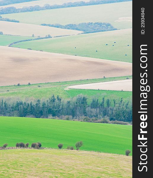 View of the countryside and valley with rolling hills and fields. View of the countryside and valley with rolling hills and fields