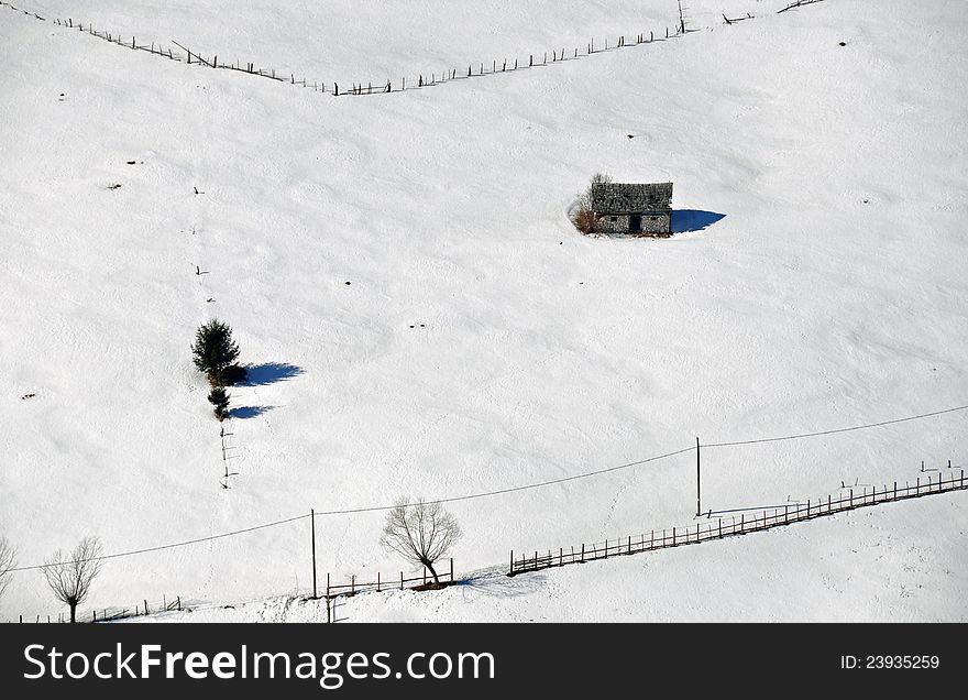 Wooden chalet in the midlle of the snow and fence. Wooden chalet in the midlle of the snow and fence