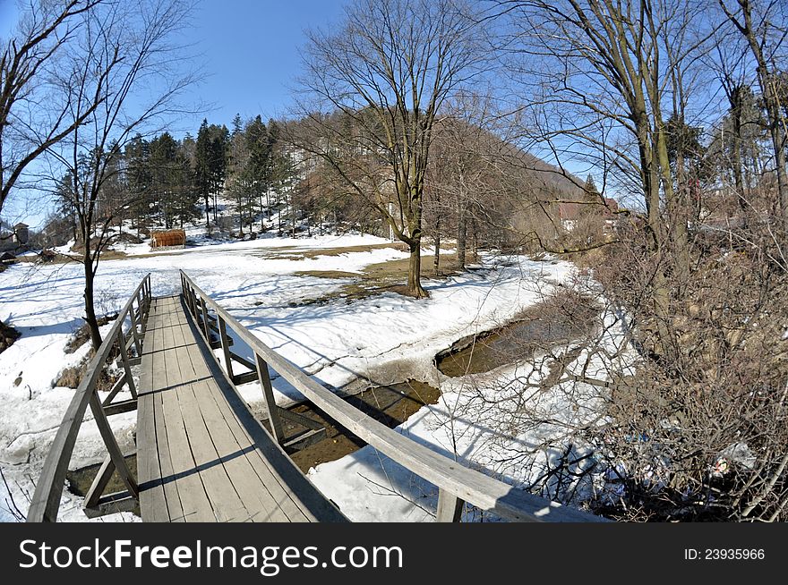 Wooden bridge going to picnic place in sunny winter day