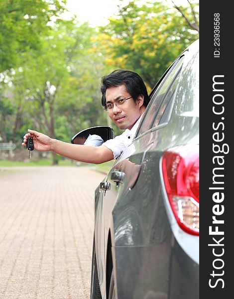 Young man in the car show the key