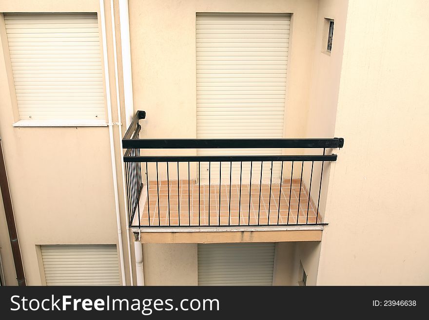 Closeup of small empty balcony with closed window and door