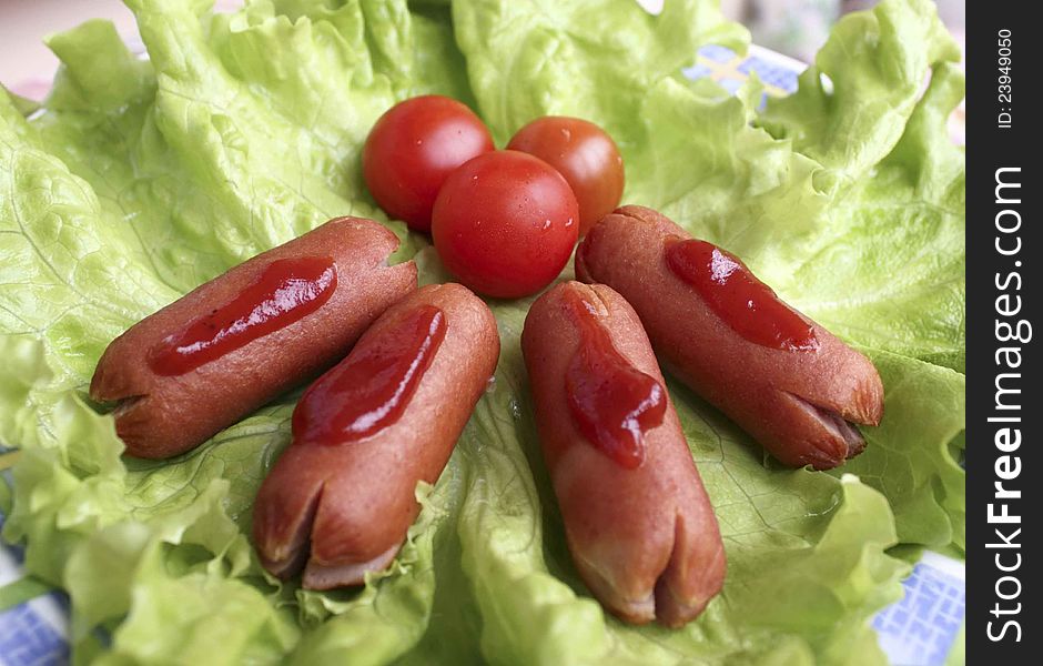 Cooked sausage with lettuce and tomatoes cherry