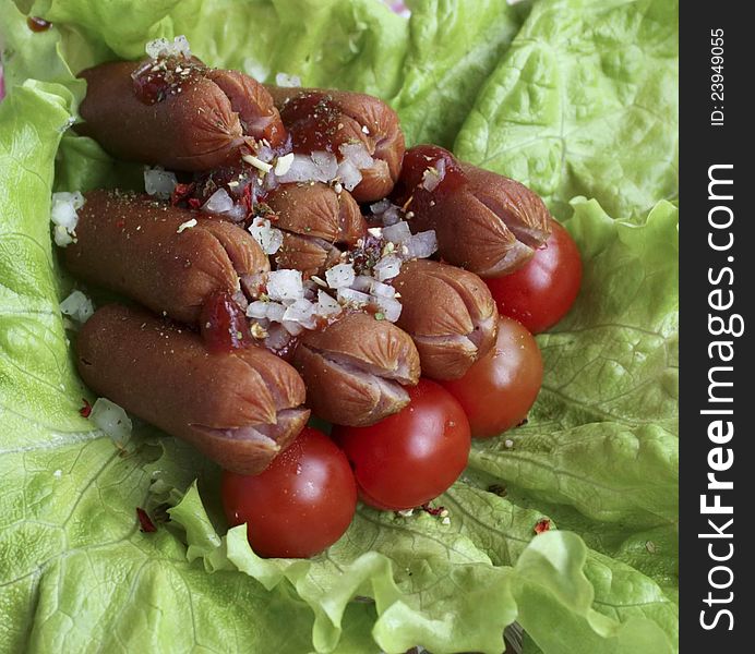 Cooked sausage with lettuce,tomatoes cherry,and onion