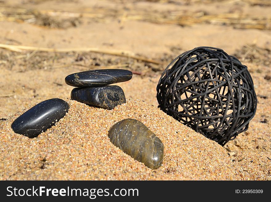 Stones in the sand by the sea and a terrakotta ball. Stones in the sand by the sea and a terrakotta ball