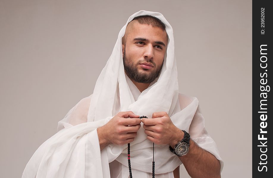 Young arabian model in studio with white textile