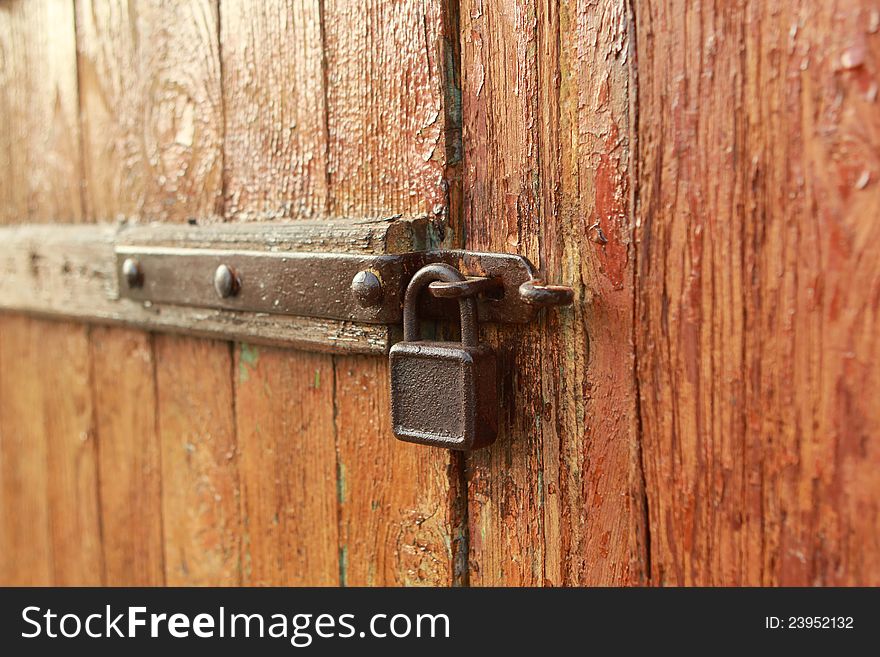 The old rusty lock on a wooden door. The old rusty lock on a wooden door.