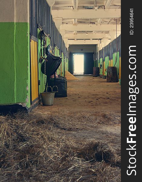 Passage of the stable, saddle, hay and a bucket with water. Passage of the stable, saddle, hay and a bucket with water