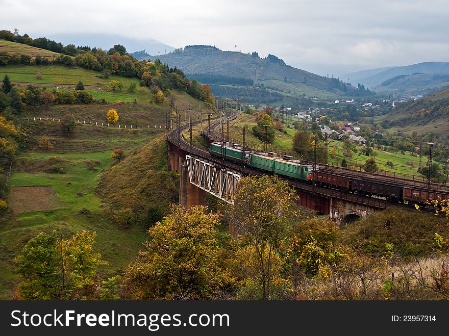 Two electric locomotives with freight train in Carpathian mountains