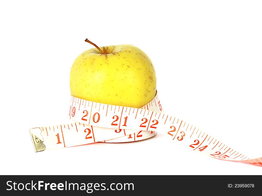 Healthy eating and dieting concept with a ripe juicy apple wrapped in a tape measure, studio on white