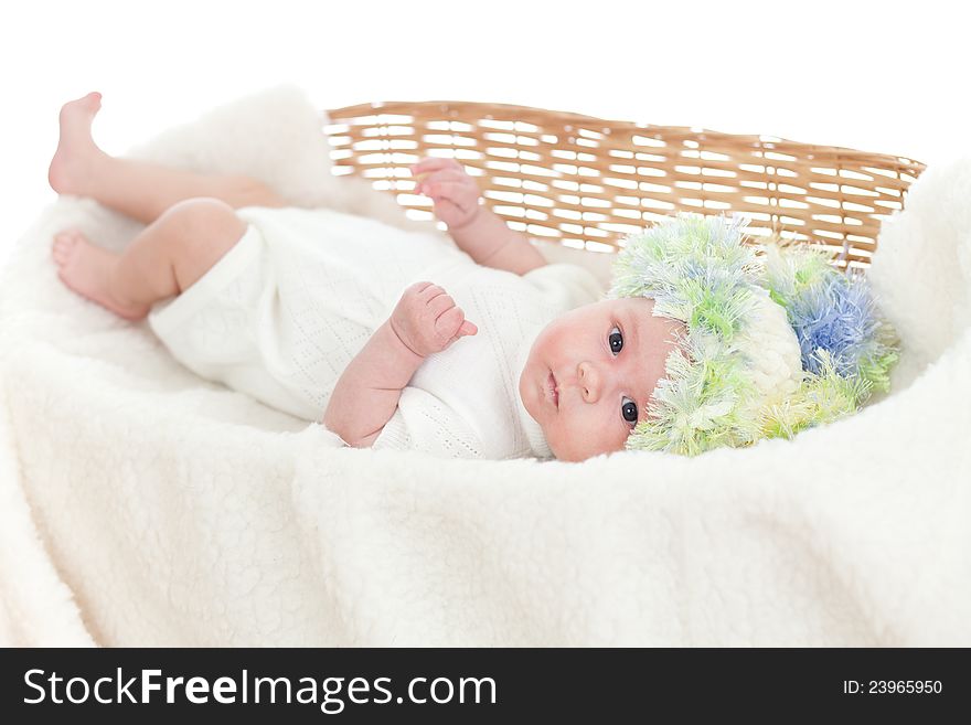 Newborn baby weared a cap in a wicker basket