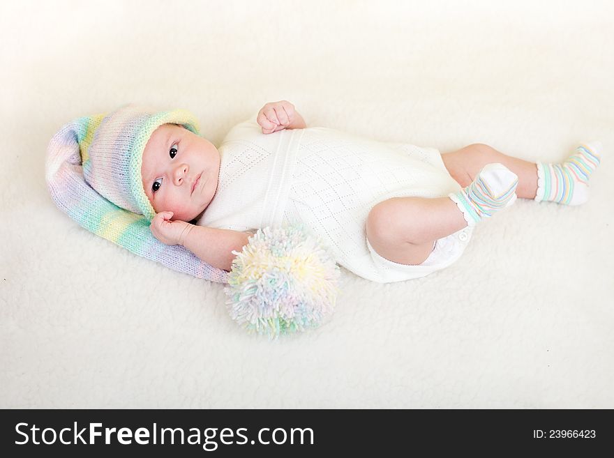 Infant baby dressed funny hat lying on white
